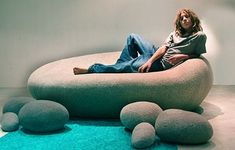 a man sitting on top of a bean bag chair in the middle of a room