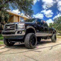 a large black truck parked in front of a house