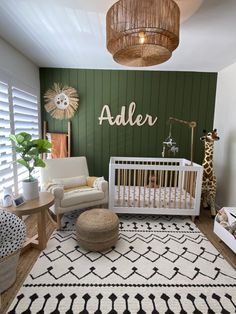 a baby's room with green walls, white furniture and a rug on the floor