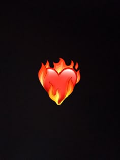 a red heart with flames on it in the dark