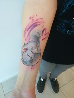 an elephant tattoo on the right arm and leg with watercolor splashes around it