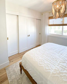 an instagramted photo of a white bed in a bedroom with closets on either side