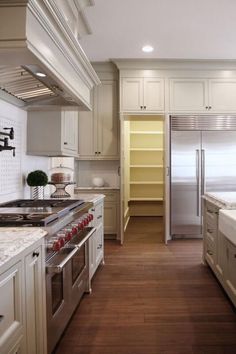 a kitchen with white cabinets and stainless steel appliances