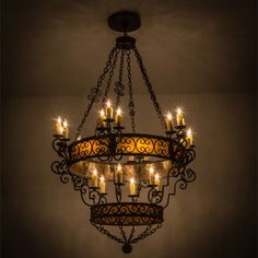 a chandelier with lit candles hanging from it's sides in a dark room