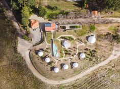 an aerial view of the house and its surrounding area, with water tanks in the foreground