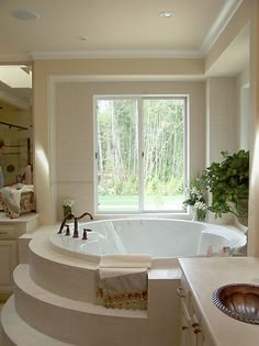 a large white bath tub sitting next to a window