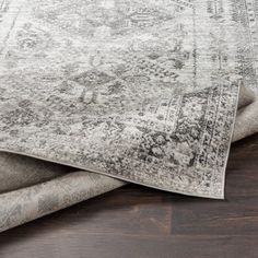 two rugs sitting on top of each other in front of a wooden flooring