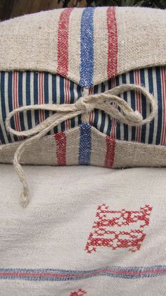 an old pillow is tied up and sitting on top of another cushion with the word love written in red, white, and blue