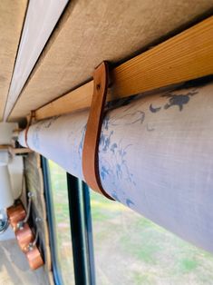 the inside of a bus with wood trim and curtains on it's windowsill