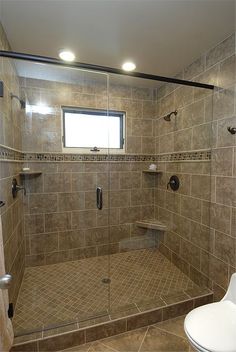 a bathroom with a walk in shower next to a toilet