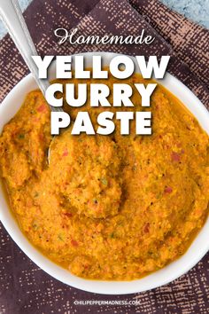 a bowl filled with yellow curry paste on top of a table