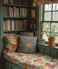 a window seat in front of a bookshelf filled with lots of books and plants