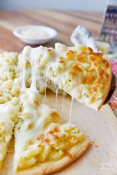 a slice of cheese pizza on a wooden cutting board with a bite taken out of it