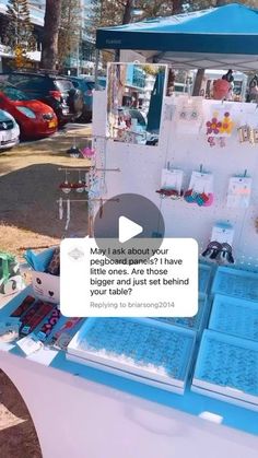 a blue and white table with lots of items on it in front of some parked cars