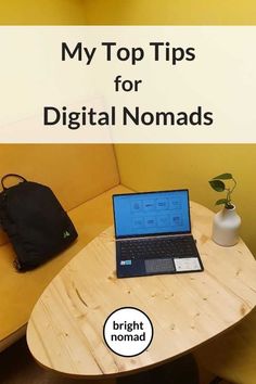 a laptop computer sitting on top of a wooden table next to a black bag and backpack