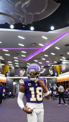 a football player is standing in the locker room with his helmet on and looking down