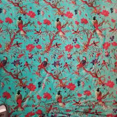 a blue background with red flowers and birds on it is shown in the middle of this photo