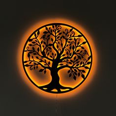 an illuminated clock with a tree on it