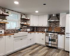 a kitchen with white cabinets and wood flooring