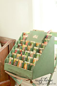 an old green box with many cards in it sitting on top of a wooden table