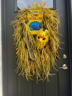 a hockey mask hanging on the front door of a house that is decorated with hay