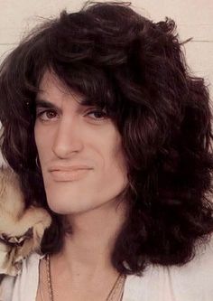 a close up of a person wearing a white shirt and holding a bird on his shoulder