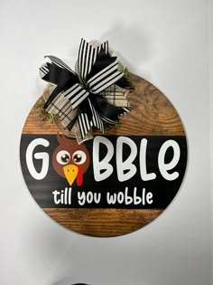 a wooden sign that says gobble till you wobble with an owl on it