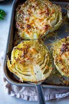 four pieces of cooked cabbage on a baking sheet with a spatula next to it