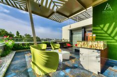 an outdoor living area with yellow chairs and green walls