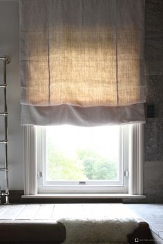 a window in a room with a rug on the floor next to it and a radiator