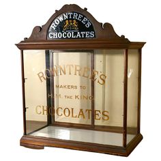 an old fashioned chocolate shop display case on a wooden table in front of a wall