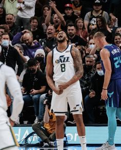 a basketball player is standing in front of the crowd with his mouth open and eyes closed