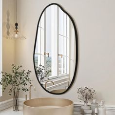 a bathroom with a large oval mirror on the wall