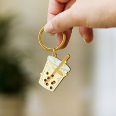 a hand holding a keychain with a coffee cup on it