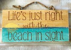 a wooden sign that says life's just right with the beach in sight on it