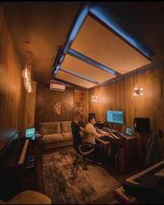 a man sitting in front of a computer on top of a wooden desk next to a couch