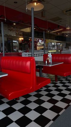 a restaurant with checkered floor and red booths