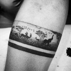 a black and white photo of some animals in the woods on a man's arm