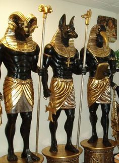 three statues of egyptian gods are on display