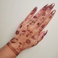 a woman's hand with henna tattoos on it