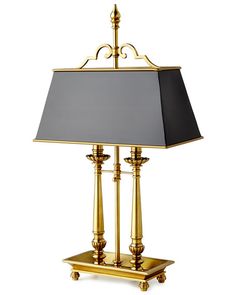 a lamp that is on top of a stand with a black and gold shade over it