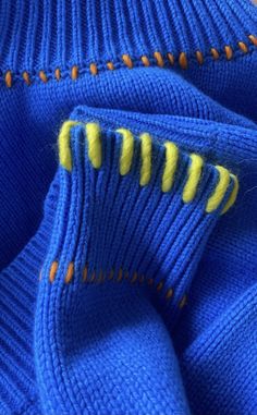 a blue sweater with yellow stitchs on it