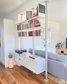 a living room filled with furniture and bookshelves next to a wall mounted tv