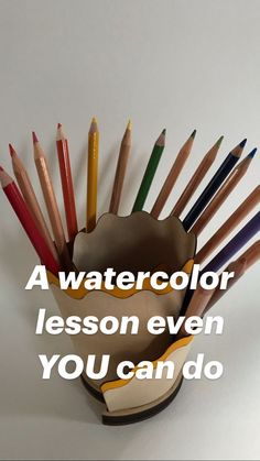 a cup filled with colored pencils sitting on top of a table