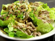 a white plate topped with lettuce covered in meat