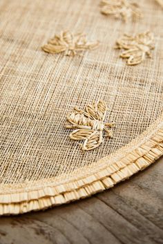 a close up of a table cloth with some flowers on the edge and one flower in the middle