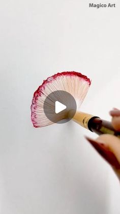 a person holding a paintbrush and painting a flower on a white wall with the words magic art written in it