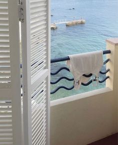 an open door with a towel hanging from it's side next to the ocean