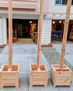 three wooden planters sitting in front of a building