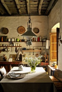 a table with plates and bowls on it in a room filled with pots and pans